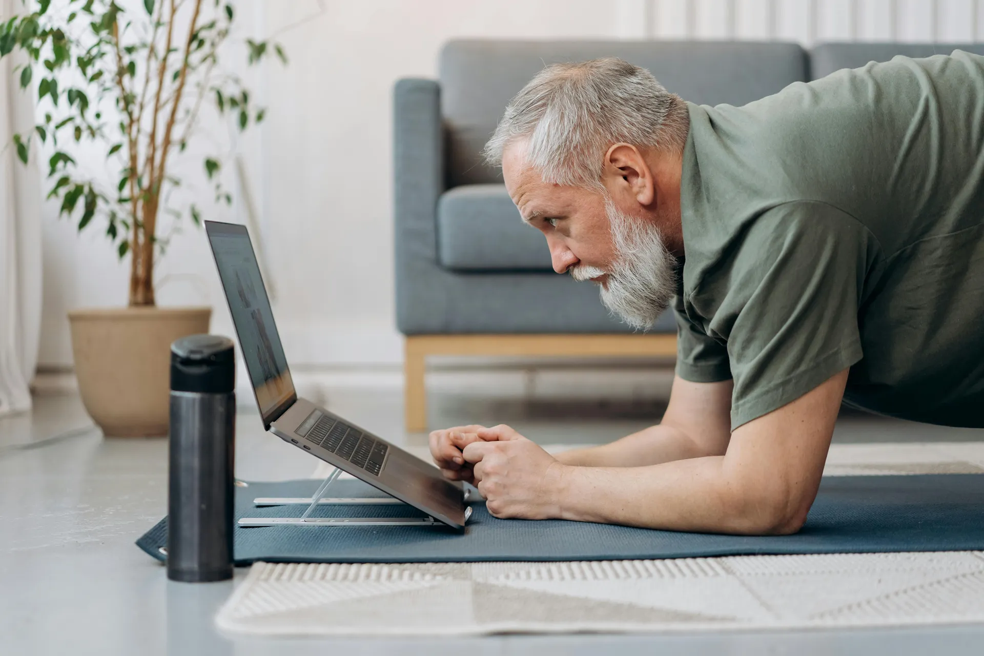 Man die een online valpreventie cursus volgt voor een laptop